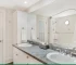 A fitted bathroom with bath, shower screen and vanity area